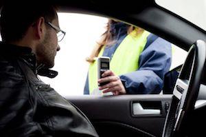 Man inside of a car looking at breathalyzer equipment.