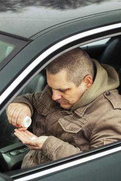 A man with pills in a car