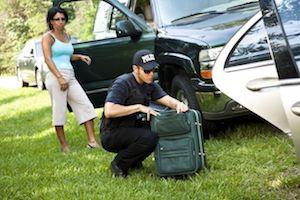 Police officer looking through a woman's suitcase.